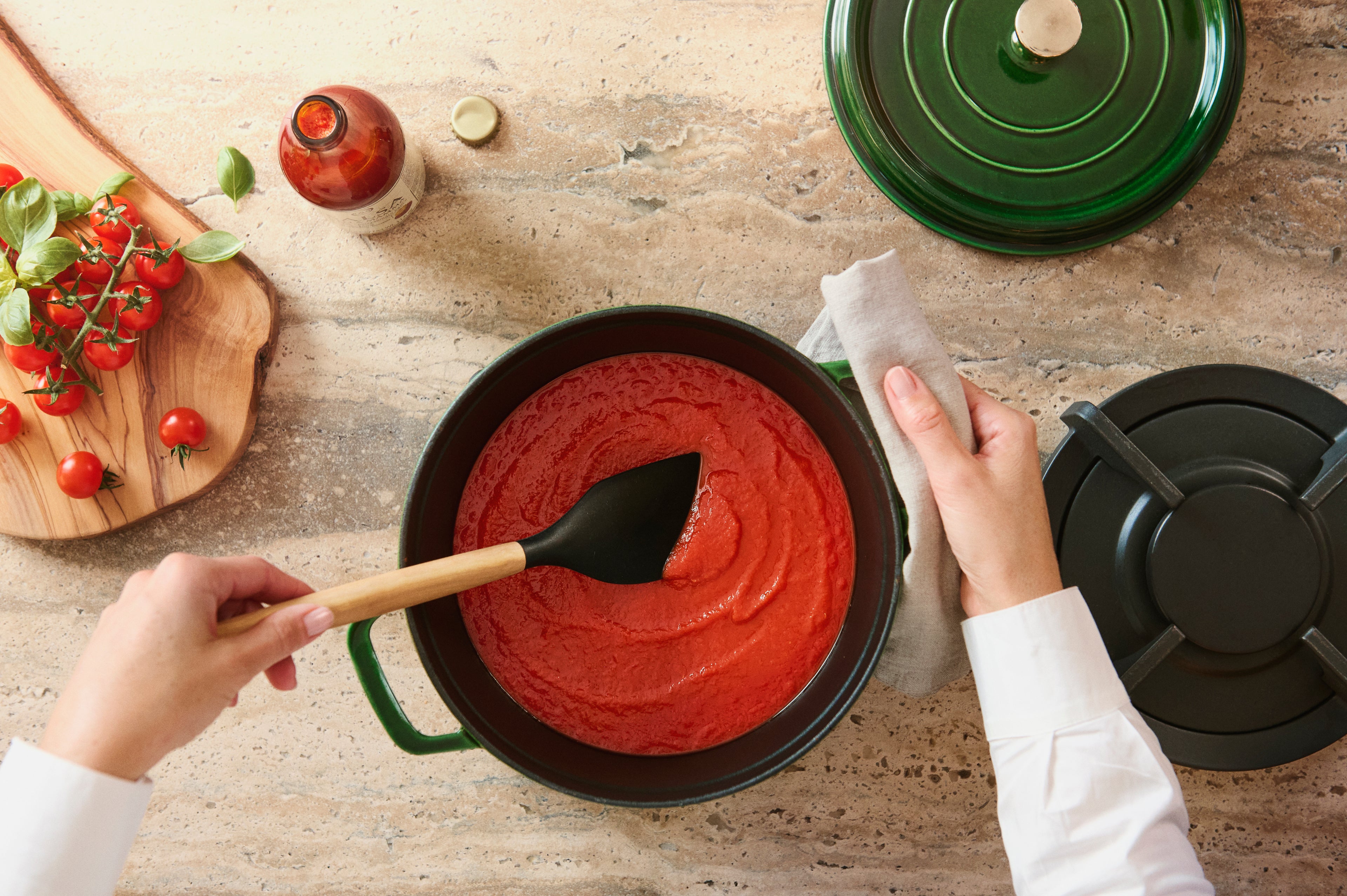 Person cooking red sauce in a Dutch oven. Capturing the heart of homemade Italian pasta and pizza dishes.