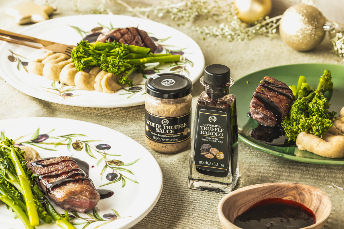 Dinner table with truffle oil, truffle sauce, and plated dishes.